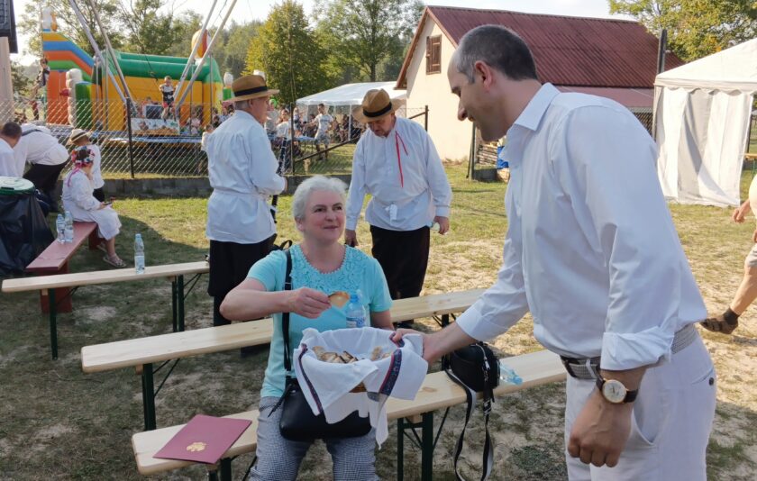 Dożynki Gminy Nowa Dęba 2024 w Alfredówce - Wiceburmistrz Marek Kopeć częstuje chlebem dożynkowym